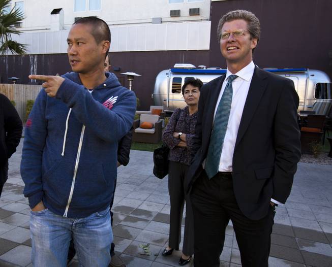 Zappos CEO Tony Hsieh, left, points out the Golden Spike during a tour of downtown Las Vegas with U.S. Department of Housing and Urban Development Secretary Shaun Donovan on Wednesday, Dec. 4, 2013.