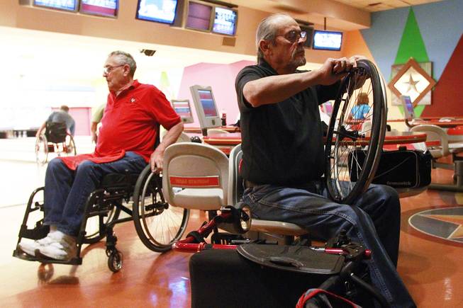 Cayetano "Sonny" Guzman tightens up the push rim on one of his wheels during the American Wheelchair Bowling Association Las Vegas Invitational tournament's doubles event Thursday, Dec. 5, 2013 at Texas Station.