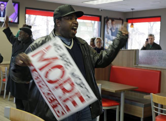 Tremaine Tribble, of Charlotte, N.C., leads a chant inside a Burger King restaurant during a protest for a raise in the minimum wage in Charlotte, N.C., Thursday, Dec. 5, 2013. Fast food workers across the country walked off their jobs to fight for a $15 an hour wage. 
