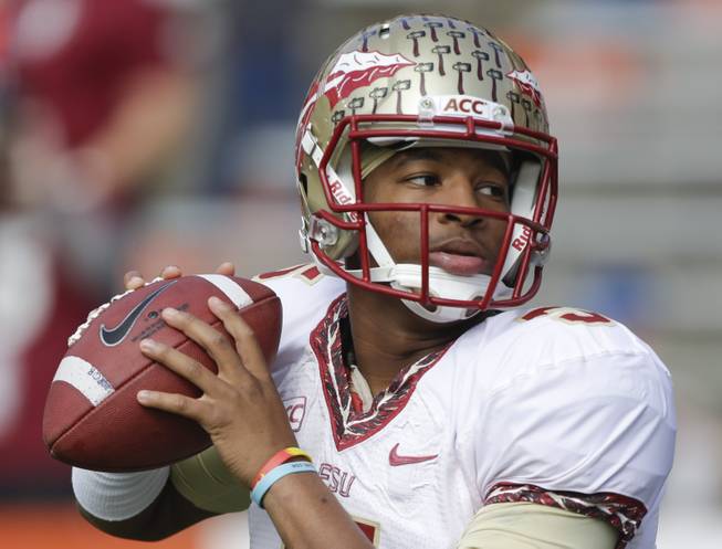 In this Nov. 30, 2013, file photo, Florida State quarterback Jameis Winston warms up before an NCAA college football game against Florida in Gainesville, Fla.
