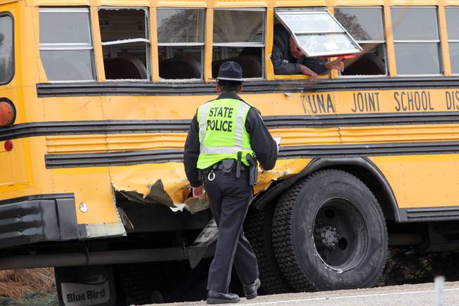 Law enforcement officials investigate the scene of a fatal crash involving a school bus on Thursday, Dec. 5, 2013, in Kuna, Idaho.