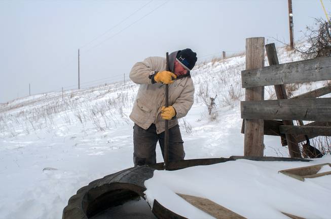 Steven Zenker breaks up ice in a water tank used for cows on his ranch near Carson, N.D., Wednesday, Dec. 4, 2013, as an arctic blast swept across the Northern Plains. Thursdays projected high is minus-6, falling to minus-10 by Saturday, with overnight lows to 24 below as a major winter storm bulldozed from the Rockies eastward. The National Weather Service forecast a foot or more of snow in some areas of the Upper Midwest, with freezing rain possible for parts of the Great Lakes.