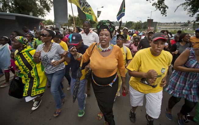 Township residents march to celebrate the life of Nelson Mandela in the street outside his old house in Soweto, Johannesburg, South Africa, Friday, Dec. 6, 2013. 