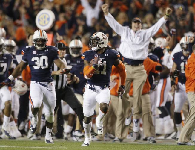 In this Nov. 30, 2013 file photo, Auburn cornerback Chris Davis (11) returns a field goal attempt 109-yards to score the winning touchdown over Alabama during the second half of an NCAA college football game in Auburn, Ala. Davis's 109-yard return of a missed field goal to beat Alabama was one of the Iron Bowl's and the season's most memorable plays. 