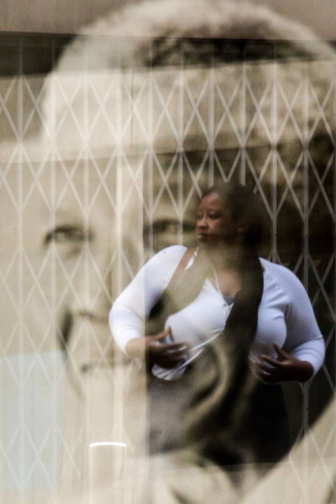 The reflection of a woman is seen in a frame with a picture of Nelson Mandela at the South African Embassy in Brussels, Friday, Dec. 6, 2013. 