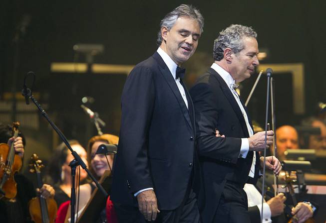 Italian-born tenor Andrea Bocelli is led to the microphone by conductor Eugene Kohn at MGM Grand Garden Arena on Saturday, Dec. 7, 2013.