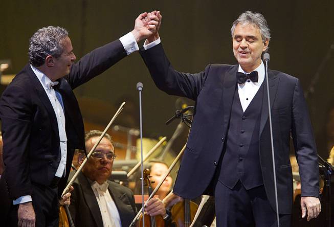 Conductor Eugene Kohn holds up the hand of Italian-born tenor Andrea Bocelli at the conclusion of a song at MGM Grand Garden Arena on Saturday, Dec. 7, 2013.