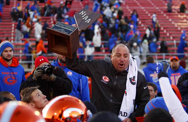 Bishop Gorman High School head football coach Tony Sanchez holds up the trophy  after Bishop Gorman beat Reed High School in the Division I state high school football championship game at Sam Boyd Stadium Saturday, Dec. 7, 2013.