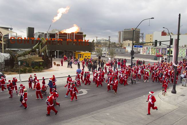 Runners dressed in Santa suits pass by the Las vegas Container Park during the annual Las Vegas Great Santa Run in downtown Las Vegas Saturday, Dec. 7, 2013. Officials said 11, 201 people participated in the event. Proceeds from the event benefit Opportunity Village, an organization that serves people with intellectual disabilities.