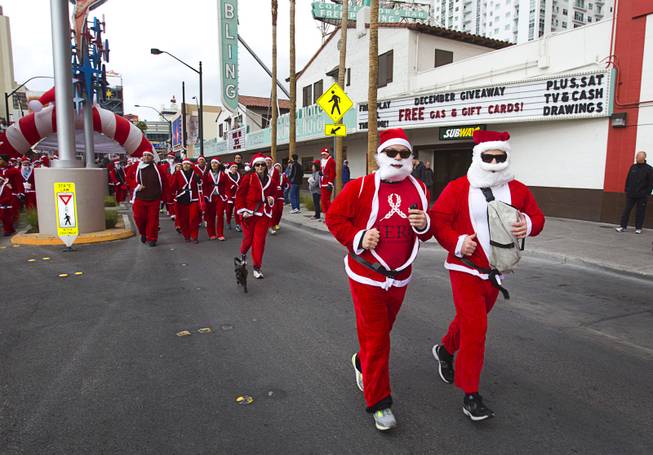 Runners dressed in Santa suits head out from the start line during the annual Las Vegas Great Santa Run in downtown Las Vegas Saturday, Dec. 7, 2013. Officials said 11, 201 people participated in the event. Proceeds from the event benefit Opportunity Village, an organization that serves people with intellectual disabilities.
