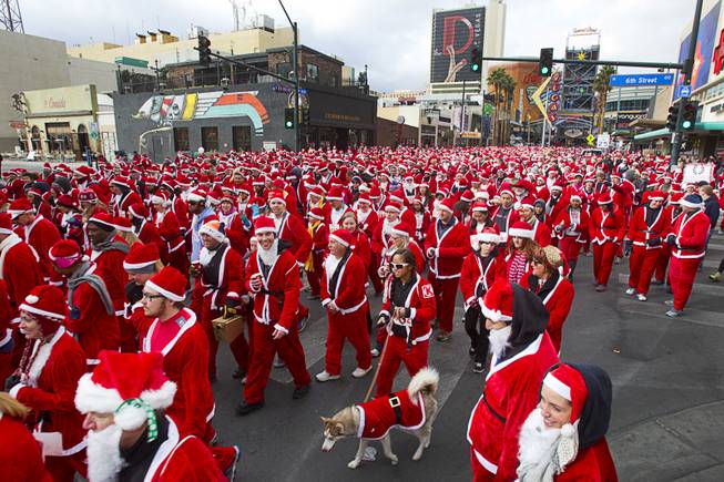 Runners dressed in Santa suits make their way to the start line during the annual Las Vegas Great Santa Run in downtown Las Vegas Saturday, Dec. 7, 2013. Officials said 11, 201 people participated in the event. Proceeds from the event benefit Opportunity Village, an organization that serves people with intellectual disabilities.