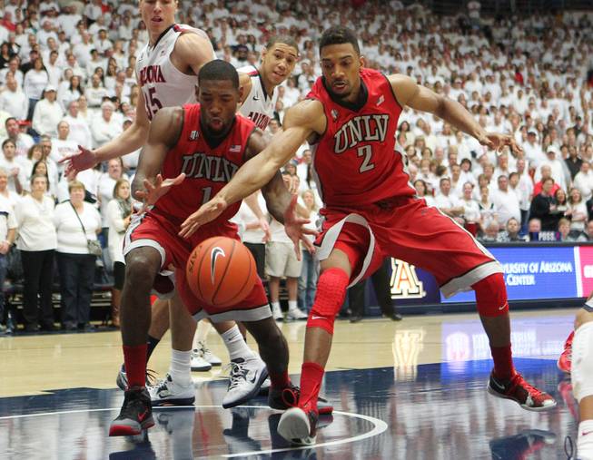 UNLV forward Roscoe Smith and Khem Birch corral a rebound against Arizona during the first half of their game at the McKale Center in Tucson Saturday, Dec. 7, 2013.