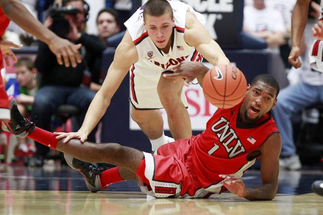UNLV forward Roscoe Smith passes off a loose ball taken from Arizona center Kaleb Tarczewski during the first half of their game at the McKale Center in Tucson Saturday, Dec. 7, 2013.