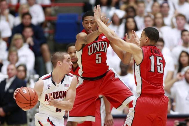 UNLV forward Chris Wood and guard Kendall Smith defend Arizona guard T.J. McConnell during their game at the McKale Center in Tucson Saturday, Dec. 7, 2013. Arizona won the game 63-58.