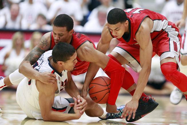 UNLV guards Bryce Dejean-Jones and Kendall Smith fight Arizona guard Nick Johnson for a loose ball during their game at the McKale Center in Tucson on Saturday, Dec. 7, 2013. Arizona won the game 63-58.