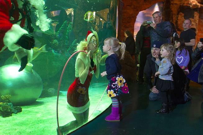 Nicole, one of Santa's helpers, gives a kiss to Penelope Christophilis, 2, of Seattle, at the Silverton Casino Hotel in Las Vegas, Nevada December 8, 2013. The underwater Santa and his helpers greet visitors and take present requests from inside the casino's 117,000-gallon aquarium on weekends in December until Christmas.