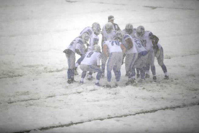 Detroit Lions quarterback Matthew Stafford (9) huddles with his team during a snow storm in the first half of an NFL football game against the Philadelphia Eagles, Sunday, Dec. 8, 2013, in Philadelphia. 