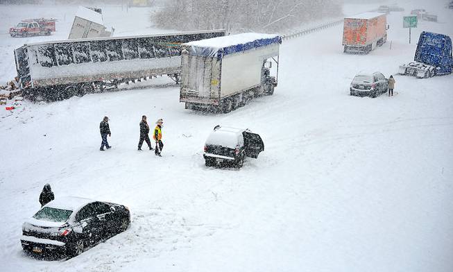 Trucks, trailers, and cars litter the southbound lanes of Interstate 81 at Salem Avenue on Sunday, Dec. 8, 2013. A powerful storm that crept across the country dumped a mix of snow, freezing rain and sleet on the Mid-Atlantic region and headed northeast Sunday, turning NFL playing fields in Pennsylvania into winter wonderlands, threatening as much as a foot of snow in Delaware and New Jersey and raising concerns about a messy morning commute.