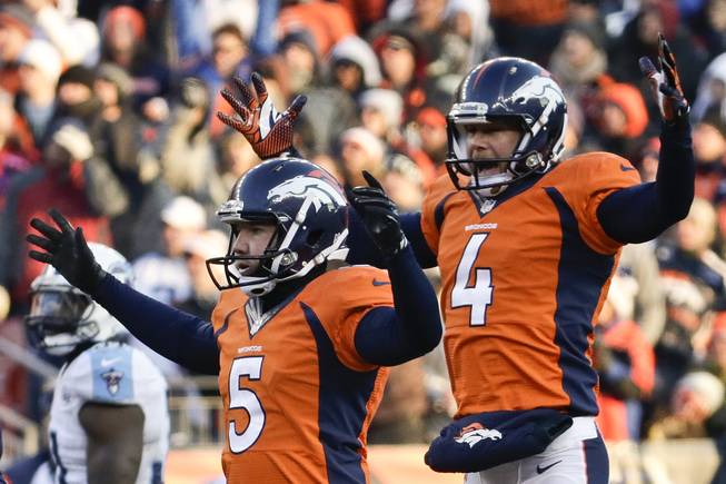 Denver Broncos kicker Matt Prater, left, celebrates a 64-yard field goal with holder Britton Colquitt during the first half of an NFL football game against the Tennessee Titans on Sunday, Dec. 8, 2013, in Denver.