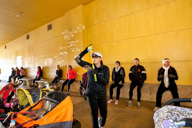 As moms and moms-to-be workout, instructor Jessica Peralta blows bubbles to entertain the babies during the Stoller Strides class, a program offered by FIT4MOM Las Vegas, at Town Square Mall in Las Vegas Friday morning, December 6, 2013.