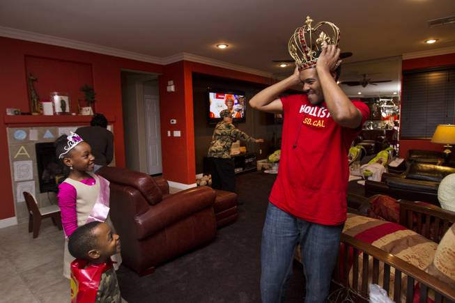 Deon Derrico shows off his giant crown to his daughter Darian, 8, and son Derrick, 3, as the family gathers to celebrate Darian's birthday Monday, Dec. 9, 2013.
