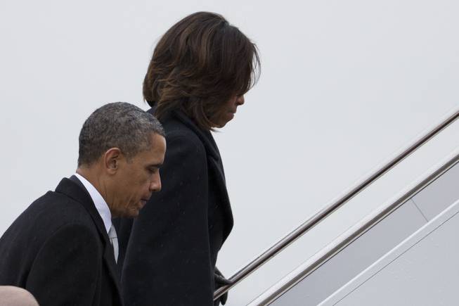 President Barack Obama and first lady Michelle Obama board Air Force One to travel to South Africa for a memorial service in honor of Nelson Mandela on Monday, Dec. 9, 2013, in Andrews Air Force Base, Md.