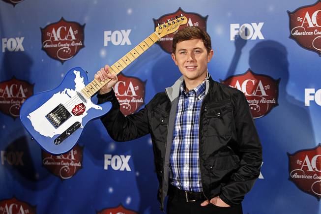 Scotty McCreery stands with his award for Breakthrough Artist of the Year during the 4th annual American Country Awards at Mandalay Bay Events Center on Tuesday, Dec. 9, 2013.