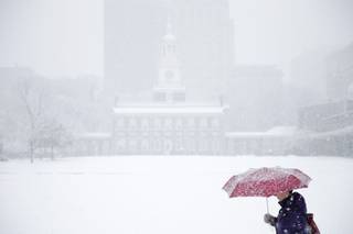 A woman walks past Independence Hall during a winter snowstorm Tuesday, Dec. 10, 2013, in Philadelphia. Accumulations of 3 to 6 inches were expected as the National Weather Service issued a winter storm warning for the Eastern Seaboard, including Baltimore, Washington, D.C., Philadelphia and Wilmington, Del.  
