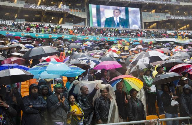 People cheer as President Barack Obama, shown on a big screen, speaks to crowds attending the memorial service for former South African president Nelson Mandela at the FNB Stadium in Soweto near Johannesburg, Tuesday, Dec. 10, 2013. World leaders, celebrities, and citizens from all walks of life gathered on Tuesday to pay respects during a memorial service for the former South African president and anti-apartheid icon.