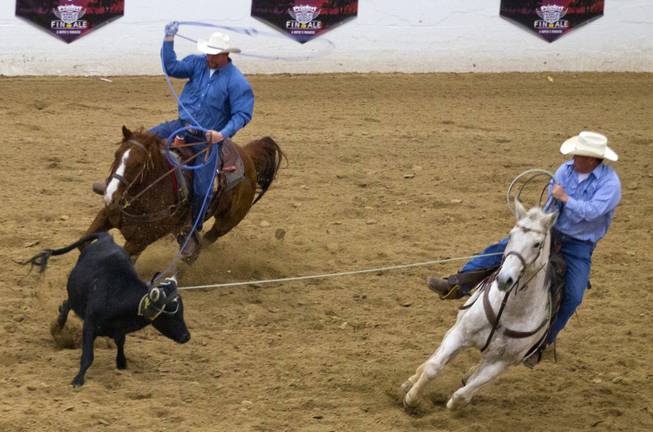 (from left) Top-seeded pair Gordon L. Nikolaus Jr. and Kiley Reidhead work to rope a steer quickly to win the XIII World Series of Team Roping (WSTR) Finals at the South Point Hotel Wednesday, Dec. 11, 2013.