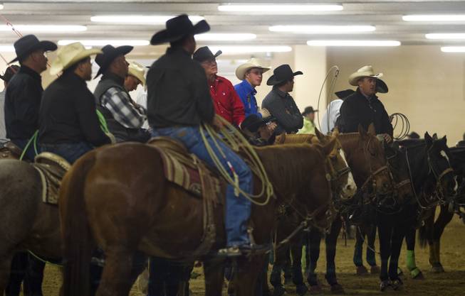 Participants gather about video feeds to watch the action in the ring during the XIII World Series of Team Roping (WSTR) Finals at the South Point Hotel Wednesday, Dec. 11, 2013.