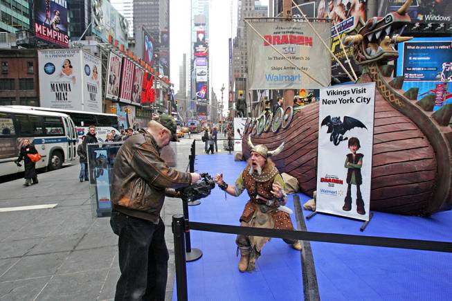 A man dressed as a Viking is filmed in New York's Times Square next to a 40-foot Viking ship to promote the movie "How To Train Your Dragon," on Tuesday, March 23, 2010. 