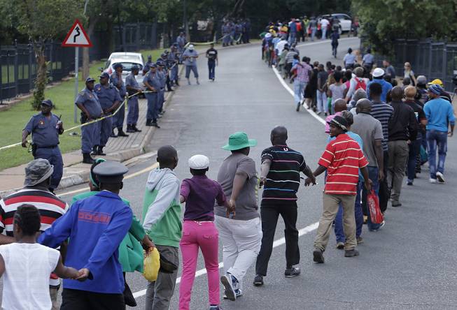 Hundreds of people  join hands while going up  a hill to view the body of former South African president Nelson Mandela in Pretoria South Africa, Wednesday, Dec. 11, 2013. 