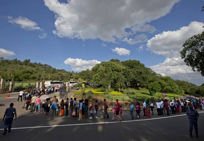 People queue to see the body of Nelson Mandela at the Union Buildings in Pretoria, South Africa, Wednesday Dec. 11, 2013, where his casket lies in state for three days. Each morning his remains will be transported from the mortuary to the government buildings.