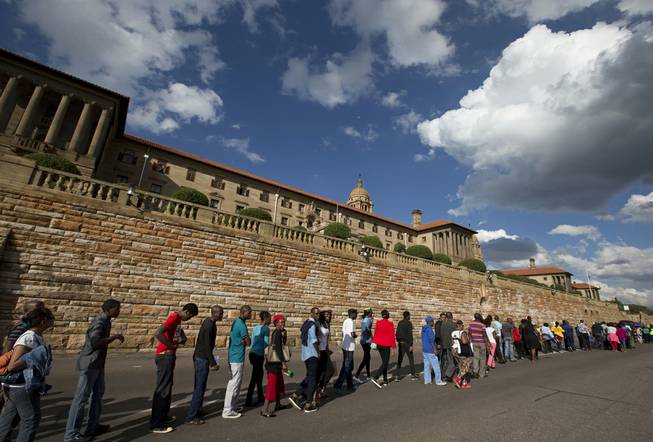 People queue to see the body of Nelson Mandela at the Union Buildings in Pretoria, South Africa, Wednesday Dec. 11, 2013, where his body lies in state for three days. Each morning his remains will be transported from the mortuary to the government buildings.