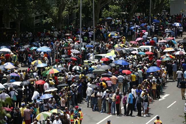 People queue up to get on buses to be taken to Union Buildings, where the casket of former President Nelson Mandela is lying in state for three days, in Pretoria, South Africa, Wednesday, Dec. 11, 2013.  