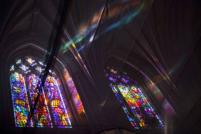Mutlicolored light from the stained glasses windows, are caught on the netting in the safety netting hanging from the ceiling of Washington National Cathedral in Washington, Wednesday, Dec. 11, 2013, during a  memorial service for Nelson Mandela. 