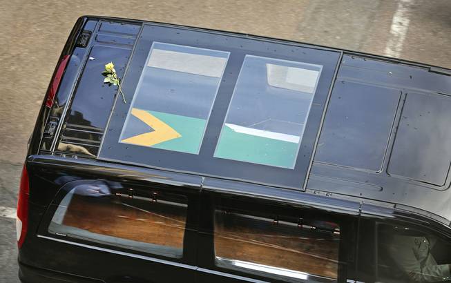 A single flower rests on the roof of the car carrying the coffin of former South African president Nelson Mandela as it makes its way through the streets of Pretoria, South Africa, Wednesday, Dec. 11, 2013. 