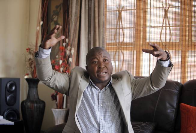 Thamsanqa Jantjie gesticulates at his home during an interview with the Associated Press in Johannesburg, South Africa,Thursday, Dec. 12, 2013. Jantjie, the man accused of faking sign interpretation next to world leaders at Nelson Mandela's memorial, told a local newspaper that he was hallucinating and hearing voices.