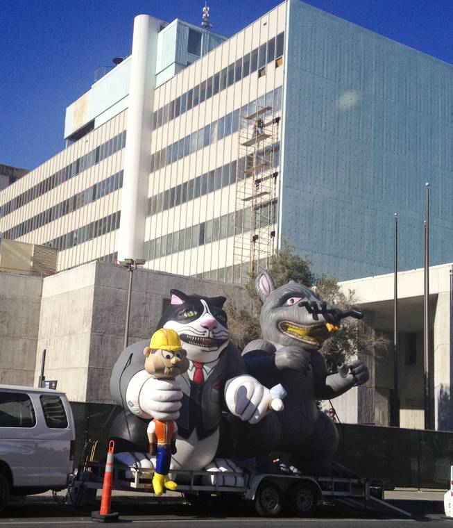 An inflated rat and cat holding a construction worker stand vigil at the old Clark County courthouse, 200 S. 3rd St Thursday, Dec. 12, 2013.