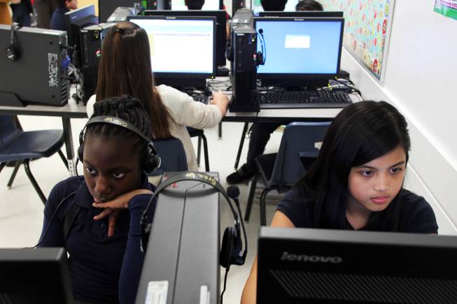 Rayven Lewis, left, and Gizzle Oreto work on their Hour of Code program at Findlay Middle School Friday, Dec. 13, 2013.