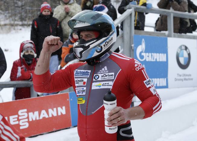 Switzerland's pilot Beat Hefti celebrates after his third-place finish with brakeman Alex Baumann in the two-man bobsled World Cup event on Friday, Dec. 13, 2013, in Lake Placid, N.Y. 
