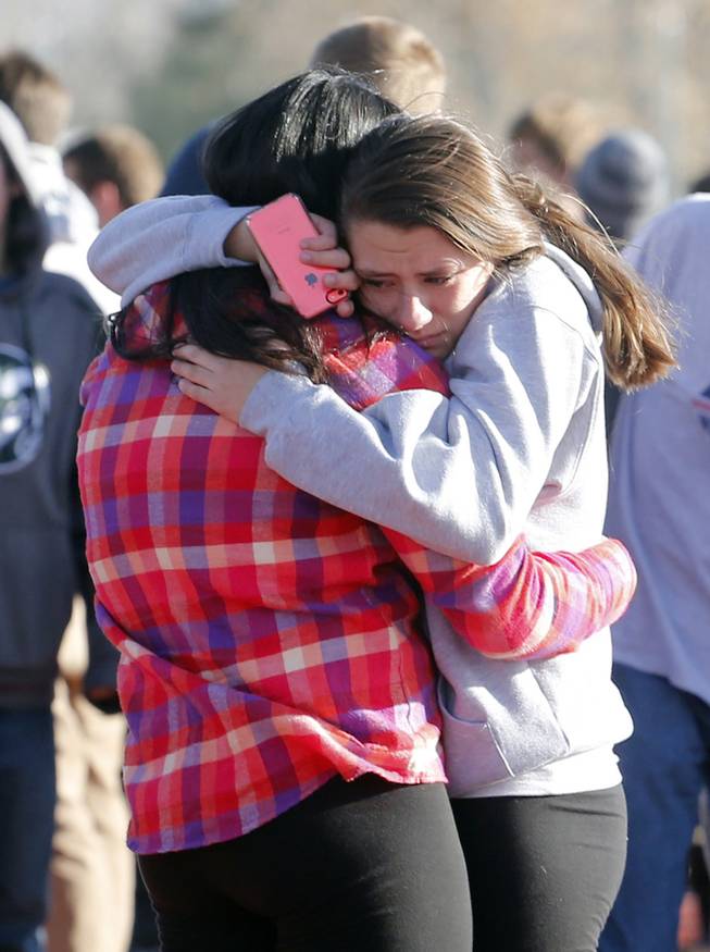 Students comfort each other outside of Arapahoe High School after a shooting on the campus in Centennial, Colo., on Friday, Dec. 13, 2013. 