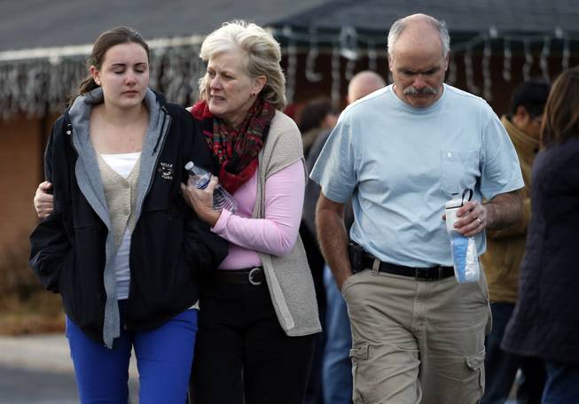 Parents pick up their daughter at a church where students from nearby Arapahoe High School were evacuated to after a shooting on the Centennial, Colo., campus Friday, Dec. 13, 2013. 