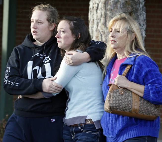 Senior Jenni Meyers, center, is hugged by her sister Mary as they leave a church with their mother Julie after they were reunited after a shooting at nearby Arapahoe High School in Centennial, Colo., on Friday, Dec. 13, 2013. 