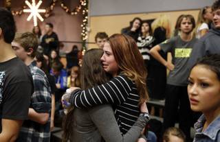 Freshman Allie Zadrow, center right, hugs classmate Liz Reinhardt at a church after a shooting at nearby Arapahoe High School in Centennial, Colo., on Friday, Dec. 13, 2013. Students from the school were evacuated to the church. Arapahoe County Sheriff Grayson Robinson said the shooter shot two others at the school before apparently killing himself.