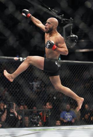 Defending champ Demetrious Johnson celebrates after knocking out Joseph Benavidez in the first round of their UFC flyweight mixed martial arts title fight in Sacramento, Calif., Saturday, Dec. 14, 2013.