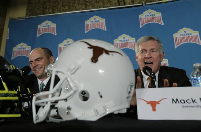 Oregon coach Mark Helfrich, left, and Texas coach Mack Brown, right, take part in a Valero Alamo Bowl news conference, Thursday, Dec. 12, 2013, in San Antonio. Texas and Oregon will play in the bowl game Dec. 30.