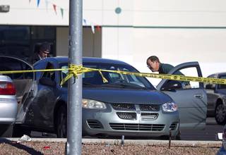 Metro Police detectives and crime scene analysts investigate a fatal shooting in front of a furniture store on Spring Mountain Road Sunday, Dec. 15, 2013.