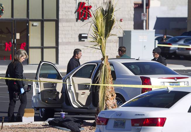 Metro Police and crime scene analysts investigate a fatal shooting in front of a furniture store on Spring Mountain Road Sunday, Dec. 15, 2013.